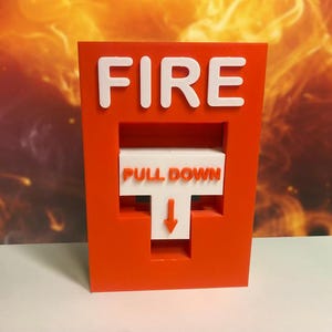 Könnte beinhalten: Ein leuchtend roter Feuermelder mit dem Wort "FIRE" in weißen Blockbuchstaben oben. Darunter steht auf einem weißen Feld "PULL DOWN" mit einem nach unten zeigenden Pfeil. Der Hintergrund zeigt einen orange-gelben Farbverlauf.