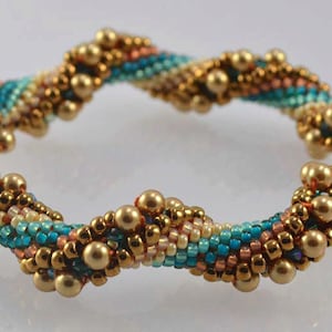 May include: A beaded bracelet with a spiral design. The bracelet is made with gold, turquoise, and peach colored beads.