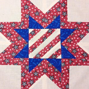 May include: A white ceramic mug with a black handle and the text "But First, Coffee" in a bold, black font. The mug is set against a blurred background, suggesting a cozy setting.