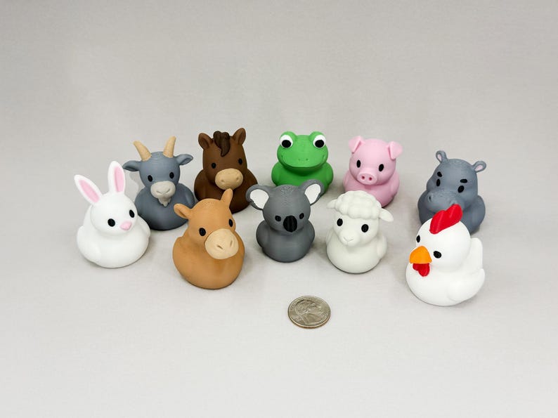 May include: A collection of ten colorful animal figurines, including a white rabbit, a gray goat, a brown horse, a green frog, a pink pig, a gray koala, a white sheep, a brown donkey, a gray hippo, and a white chicken. A U.S. quarter is included for scale.