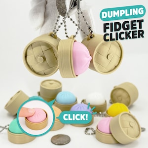 May include: A collection of dumpling fidget clickers featuring tan bamboo steamer cases and colorful silicone dumpling inserts. The text DUMPLING FIDGET CLICKER and CLICK! is visible. Each unit includes a metal ball chain for attachment.