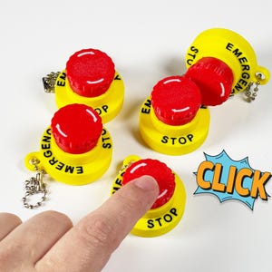 May include: Four yellow plastic emergency stop buttons with red push buttons. One button is being pressed with a finger, and a blue and orange comic book style "CLICK" sound effect is in the background.