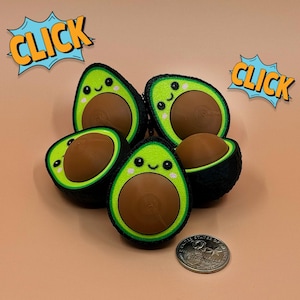 May include: A collection of avocado-shaped toys with smiling faces and brown centers. The toys are green and black, with a yellow-green border. The word "CLICK" is in a comic book style speech bubble. A US quarter is also in the image.