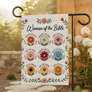 May include: A garden flag featuring the text "Women of the Bible" with colorful floral illustrations. Each flower represents a woman from the Bible, with phrases like "Believe like Mary" and "Love like Ruth" displayed.
