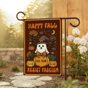 May include: A brown garden flag with the words "HAPPY FALL" and "RESIST FASCISM" in orange. The flag features a ghost wearing a witch hat, a pumpkin, flowers, and the text "FUCK TRUMP".