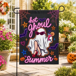 May include: A black garden flag featuring a white ghost wearing red high heels and pink sunglasses, holding a pink cocktail with an orange slice. The text reads hot ghoul summer in pink neon-style script, surrounded by bats, stars, and spiderwebs.