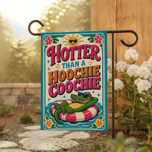 May include: A rectangular garden flag with a teal border features the text "Hoter than a Hoochie Coochie" in red and orange. A cartoon alligator wearing sunglasses floats in a pool on a pink and white striped inner tube. The sun is wearing sunglasses.