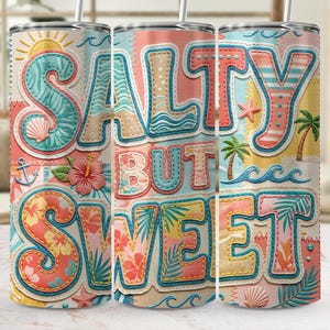 Puede incluir: Un vaso colorido con el texto "Salty But Sweet" en un diseño de patchwork. El diseño incluye elementos de playa como un sol, conchas marinas, palmeras y olas. El vaso tiene una pajita y probablemente se usa para bebidas frías.