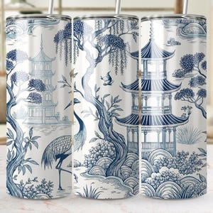 May include: A white tumbler with a blue and white design of a pagoda, cranes, and floral patterns. The design is reminiscent of traditional Chinese porcelain.