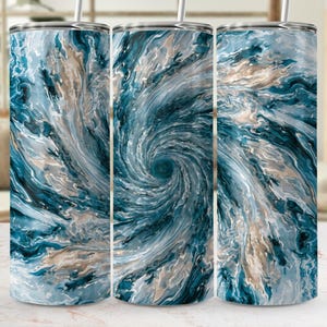May include: Three stainless steel tumblers with a swirling abstract design in shades of blue, white, and tan. Each tumbler has a silver lid and a straw. The design resembles a vortex or a watercolor painting.