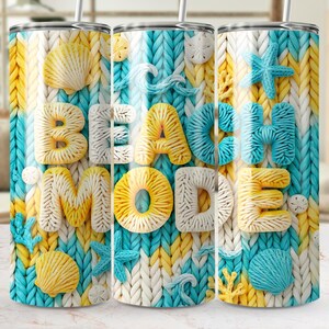 May include: A stainless steel tumbler with a knitted pattern in white, yellow, and turquoise. The words "BEACH MODE" are in 3D lettering, with seashell and starfish accents. The tumbler has a straw.
