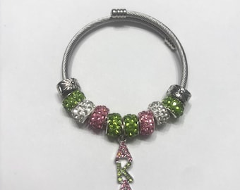 Vrouwenclubarmband: roze en groene kristallen bedel