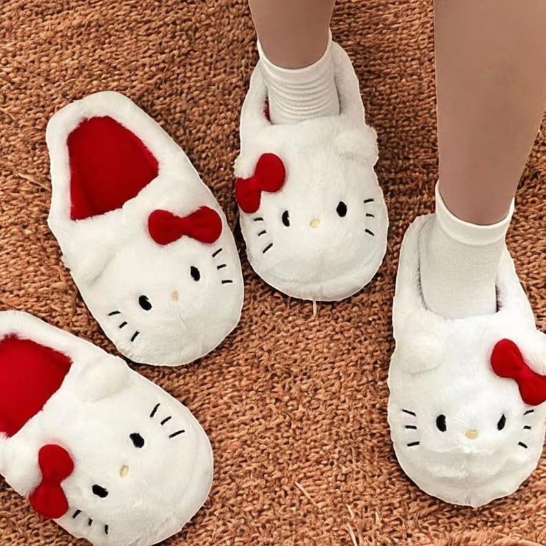 May include: Three pairs of white fuzzy slippers with red bows and a Hello Kitty face design.
