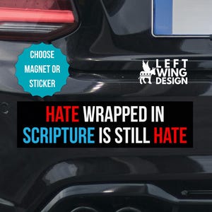Op de afbeelding: Zwarte autobumper met een rechthoekige sticker met de tekst "HATE WRAPPED IN SCRIPTURE IS STILL HATE" in wit, rood en blauw. Een turquoise sticker zegt "CHOOSE MAGNET OR STICKER". De auto heeft een "LEFT WING DESIGN" sticker.