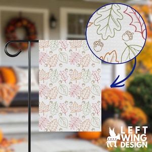 May include: A rectangular garden flag featuring a repeating pattern of autumn leaves and acorns in outline style. The leaves are colored in shades of green, orange, and red. A circular inset shows a magnified view of the pattern with text.