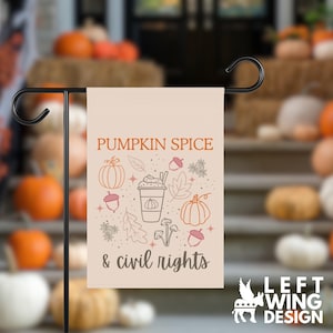 May include: A rectangular garden flag with a light beige background featuring the text PUMPKIN SPICE & civil rights in orange and dark brown. The design includes line art illustrations of a coffee cup, pumpkins, acorns, leaves, and mushrooms.