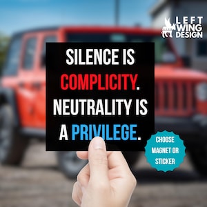May include: A black square magnet or sticker with the text "SILENCE IS COMPLICITY. NEUTRALITY IS A PRIVILEGE." in white, red, and blue. The product also features the text "CHOOSE MAGNET OR STICKER" and the "LEFT WING DESIGN" logo.