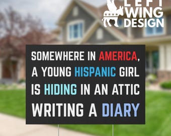 May include: Black yard sign with white text that reads "SOMEWHERE IN AMERICA, A YOUNG HISPANIC GIRL IS HIDING IN AN ATTIC WRITING A DIARY." The sign has a metal stake and a logo that says "LEFT WING DESIGN."