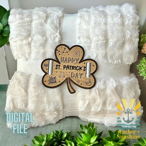 May include: A white faux fur throw blanket with a wooden shamrock cutout that says "Happy St. Patrick's Day".