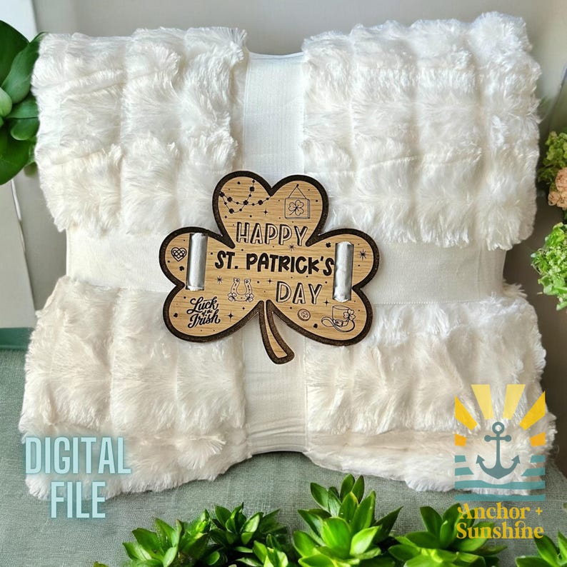 May include: A white faux fur throw blanket with a wooden shamrock cutout that says "Happy St. Patrick's Day".