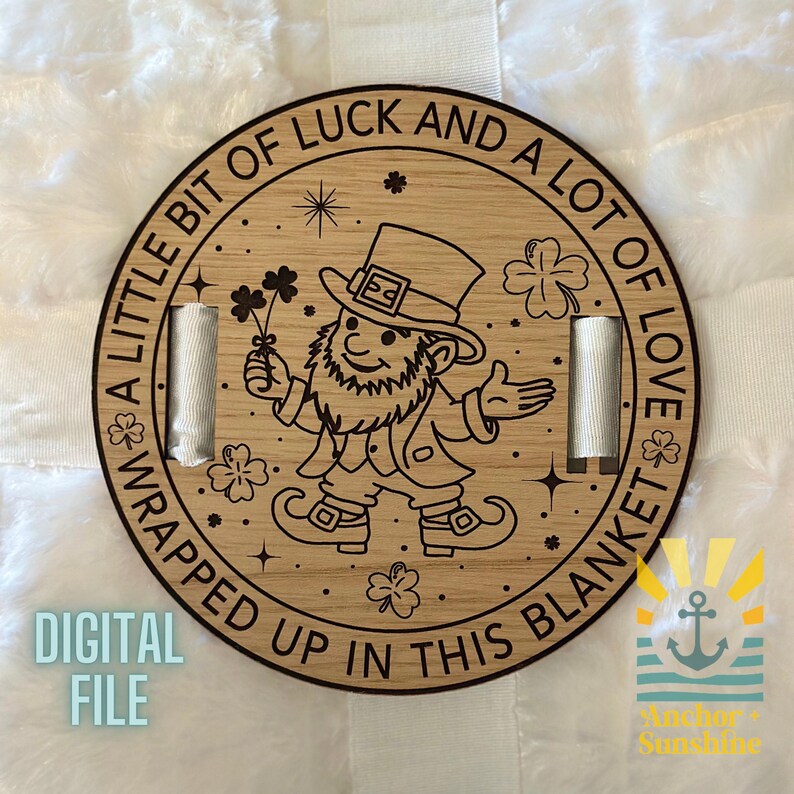 May include: A round wooden sign with a leprechaun holding a shamrock. The sign says "A little bit of luck and a lot of love wrapped up in this blanket".