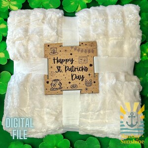 May include: White faux fur blanket with a wooden sign that says "Happy St. Patrick's Day" with a shamrock, pot of gold, and horseshoe design.