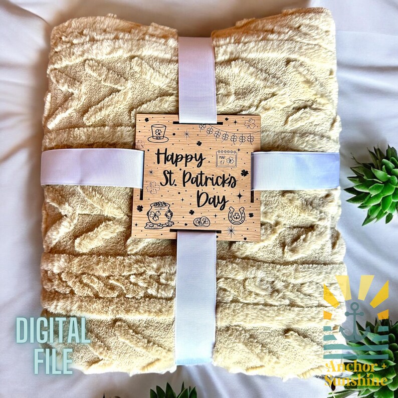 May include: A cream-colored plush blanket with a wooden sign that reads "Happy St. Patrick's Day". The sign has a shamrock, pot of gold, and horseshoe design.