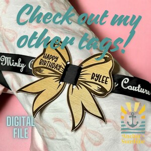 May include: A wooden bow tie gift tag with the text "Happy Birthday" and "Rylee" on it. The tag is attached to a black ribbon with the text "Minky Couture" on it. The tag is on a white and pink background with the text "Check out my other tags!" and "Digital File" on it.