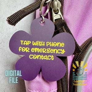May include: Purple flower-shaped keychain with the text "TAP with PHONE for emergency contact" in yellow. The keychain is attached to a backpack zipper. The words "DIGITAL FILE" are also visible.