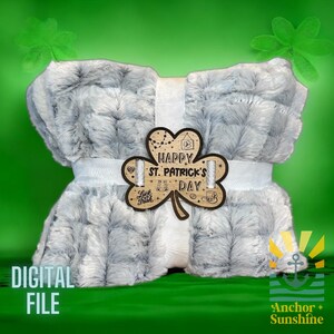 May include: A gray and white plush blanket with a wooden shamrock cutout that says "Happy St. Patrick's Day".