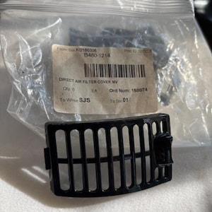 May include: A black direct air filter cover with a slotted design. The cover is in a clear plastic bag with a label that includes the text "DIRECT AIR FILTER COVER MV". The label also includes the text "B480-1214".