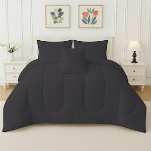 May include: A charcoal grey bed set, comprising a duvet, two pillowcases, and two decorative cushions, is presented on a bed. The bedding is neatly arranged, with a smooth, quilted texture. The bedroom setting includes framed artwork and bedside tables.