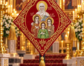 May include: A diamond-shaped red fabric banner featuring gold embroidered borders and three gold tassels. The center displays an embroidered icon of four figures with halos, including Cyrillic text reading SV MCH VERA, SOFIA, and NADEZHDA.
