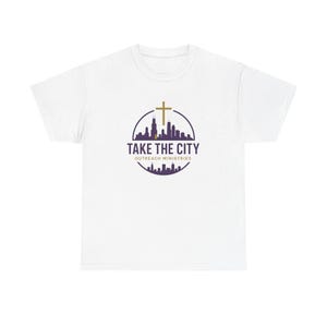 May include: White t-shirt featuring a purple and gold circular design with a cityscape, cross, and the text "TAKE THE CITY OUTREACH MINISTRIES". The design is centered on the front of the shirt.