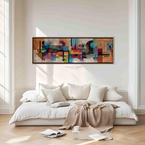 Könnte beinhalten: Abstrakter Kunstdruck auf Leinwand mit schwarzem Rahmen. Das Kunstwerk zeigt ein farbenfrohes geometrisches Design mit Formen in Rot, Blau, Gelb und Lila. Der Text "DREAM FRAME CANVAS" ist unten auf der Leinwand aufgedruckt.
