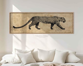 May include: A framed canvas print featuring a black and white illustration of a leopard in profile. The artwork has a vintage aesthetic, with the leopard's spots and details clearly visible against a tan background. The frame is a light brown color.