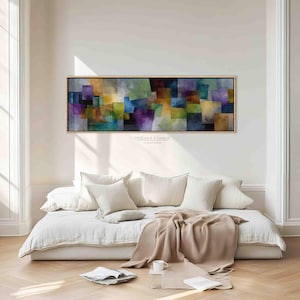 Könnte beinhalten: Rechteckige abstrakte Kunstleinwand mit goldenem Rahmen, die ein Mosaik aus farbigen Quadraten zeigt. Das Kunstwerk zeigt Farbtöne von Lila, Grün, Gelb und Blau. Der Text "DREAM FRAME CANVAS" ist unten rechts aufgedruckt.
