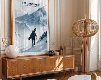 May include: A framed poster with a blue and white mountain scene and a snowboarder walking up a snowy slope. The poster has the text "I Belong Here My Dreams My Paradise".