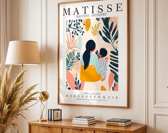 Może przedstawiać: Oprawiony wydruk artystyczny zatytułowany MATISSE PAPIERS DÉCOUPÉS przedstawiający stylizowaną ilustrację rodzica i dziecka w otoczeniu kolorowych botanicznych kształtów w odcieniach niebieskiego, żółtego i różowego, z tekstem Mother and Child BERGGRUEN & CIE.