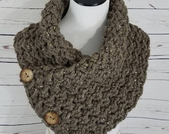May include: A brown crocheted infinity scarf with wooden buttons. The scarf is displayed on a white mannequin.
