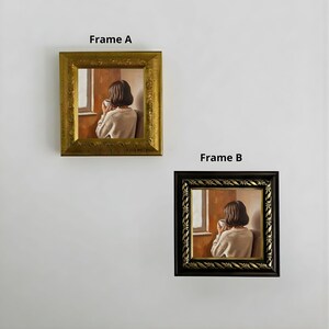 Op de afbeelding: Twee ingelijste vierkante schilderijen. Frame A heeft een gouden sierlijke lijst en Frame B heeft een zwarte sierlijke lijst. Elk schilderij toont een persoon die uit een raam kijkt en een kopje vasthoudt. De tekst "Frame A" en "Frame B" staat boven de respectievelijke frames.