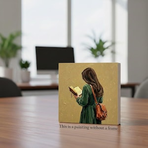 May include: A framed painting depicts a person with long brown hair reading a book, wearing a green dress and a brown satchel. The painting has a gold background and the text "This is a painting without a frame" is at the bottom.