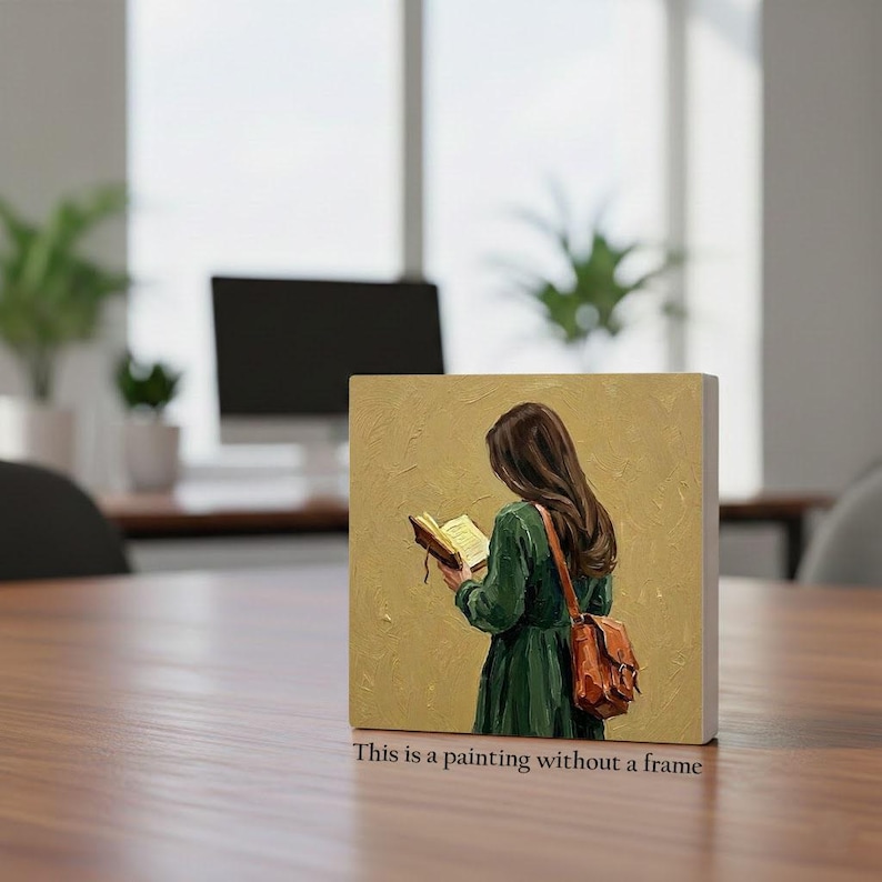 May include: A framed painting depicts a person with long brown hair reading a book, wearing a green dress and a brown satchel. The painting has a gold background and the text "This is a painting without a frame" is at the bottom.