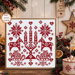 May include: A square cross stitch pattern featuring red geometric designs on a white background. The pattern includes a central candelabra with three candles, flanked by two stylized horses, gift boxes, snowflakes, and small heart motifs.
