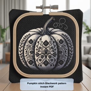 May include: A cross-stitch pumpkin design in a wooden embroidery hoop. The pumpkin is white with black floral patterns and a black stem. The background is black fabric. The text at the bottom reads "Pumpkin stitch Blackwork pattern Instant PDF."