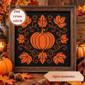 Può includere: Un motivo a punto croce quadrato in una cornice di legno scuro con una zucca arancione centrale circondata da foglie d'acero arancioni e motivi a viticcio su sfondo nero. Il testo PDF cross stitch è visibile in alto a sinistra.