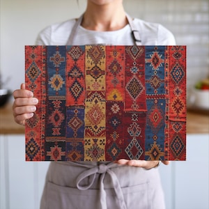 May include: A rectangular cutting board with a colorful, patterned design. The design features a patchwork of geometric shapes in shades of red, blue, yellow, and orange. The board is held by a person wearing a white shirt and apron.