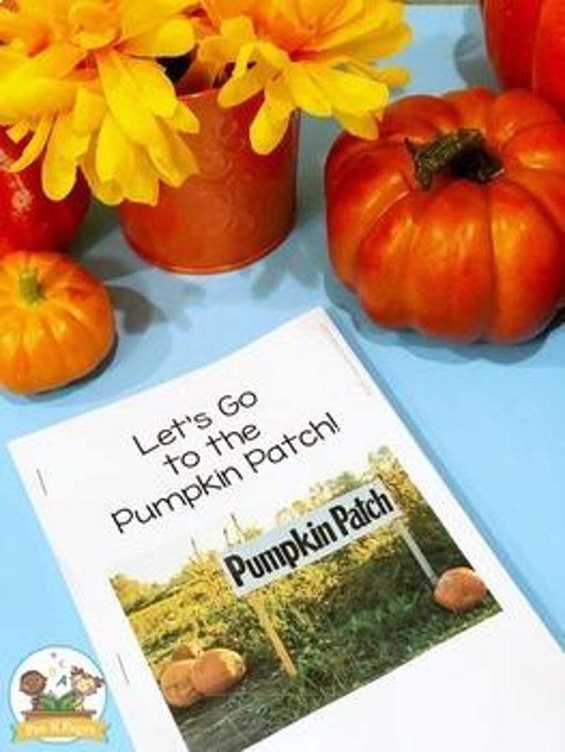 May include: A vibrant autumn scene featuring a small orange pumpkin, a larger pumpkin, and a vase of yellow flowers. A book titled "Let's Go to the Pumpkin Patch!" is in the foreground. The book's cover shows a sign that reads "Pumpkin Patch".