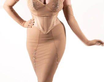 May include: A nude-colored mesh dress with a corset top and a skirt. The dress is adorned with small, sparkly embellishments.