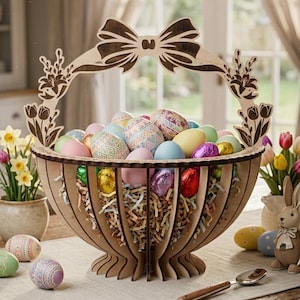 Może przedstawiać: Drewniany kosz wielkanocny wypełniony kolorowymi, zdobionymi jajkami i czekoladowymi jajkami w folii. Kosz ma dekoracyjny uchwyt w kształcie kokardy i stoi na stole.